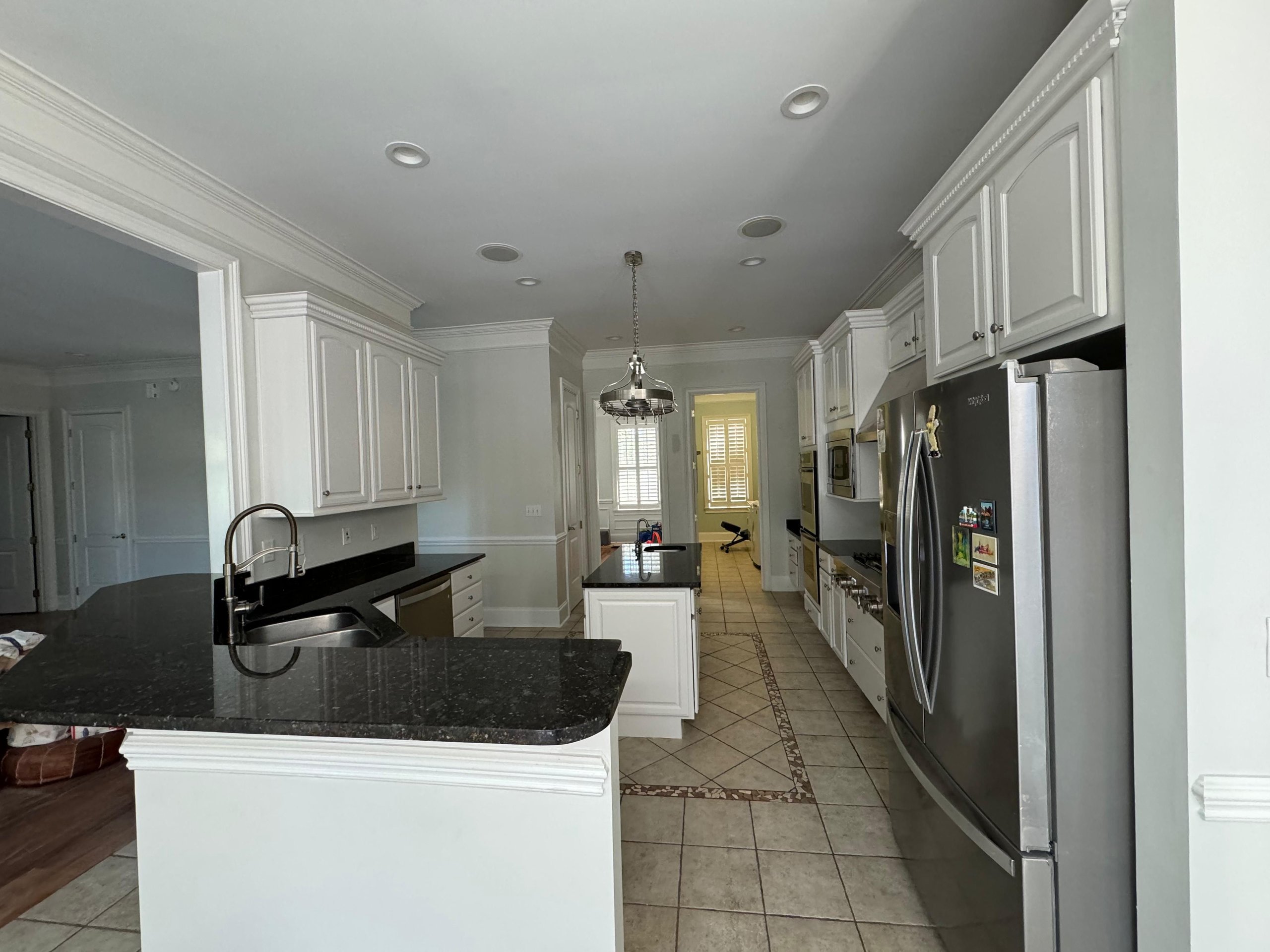 Modern white kitchen with black countertops and stainless steel appliances