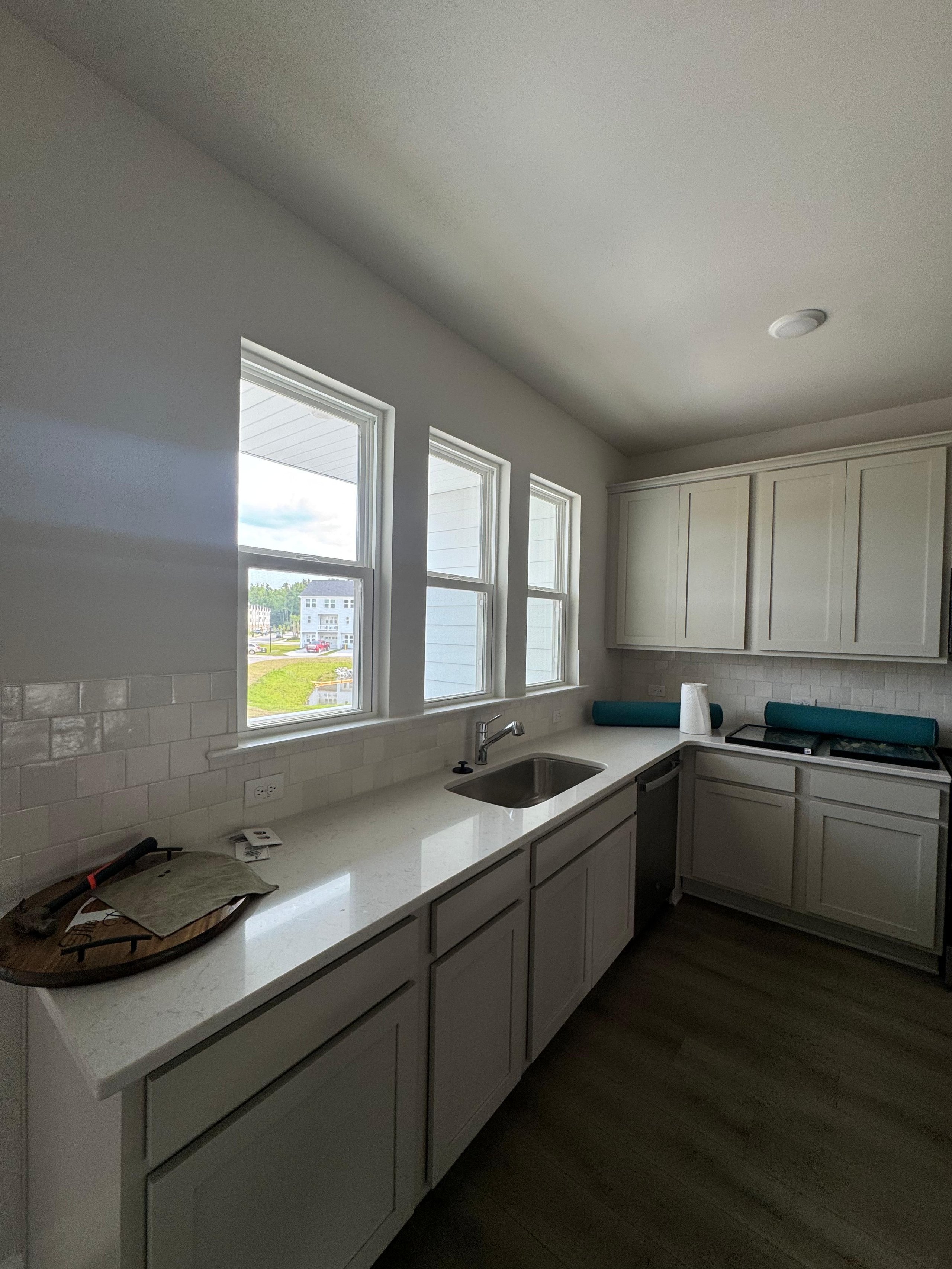 Modern kitchen with white cabinets, windows, and sink
