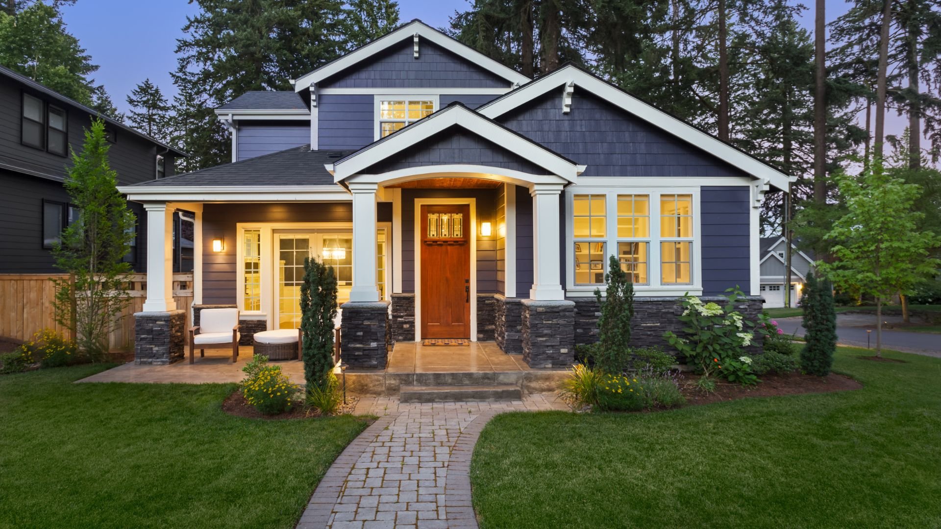 Modern craftsman-style house with stone accents and warm evening lighting